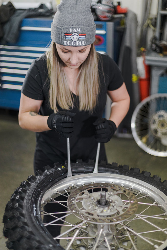 girl mechanic changing tire